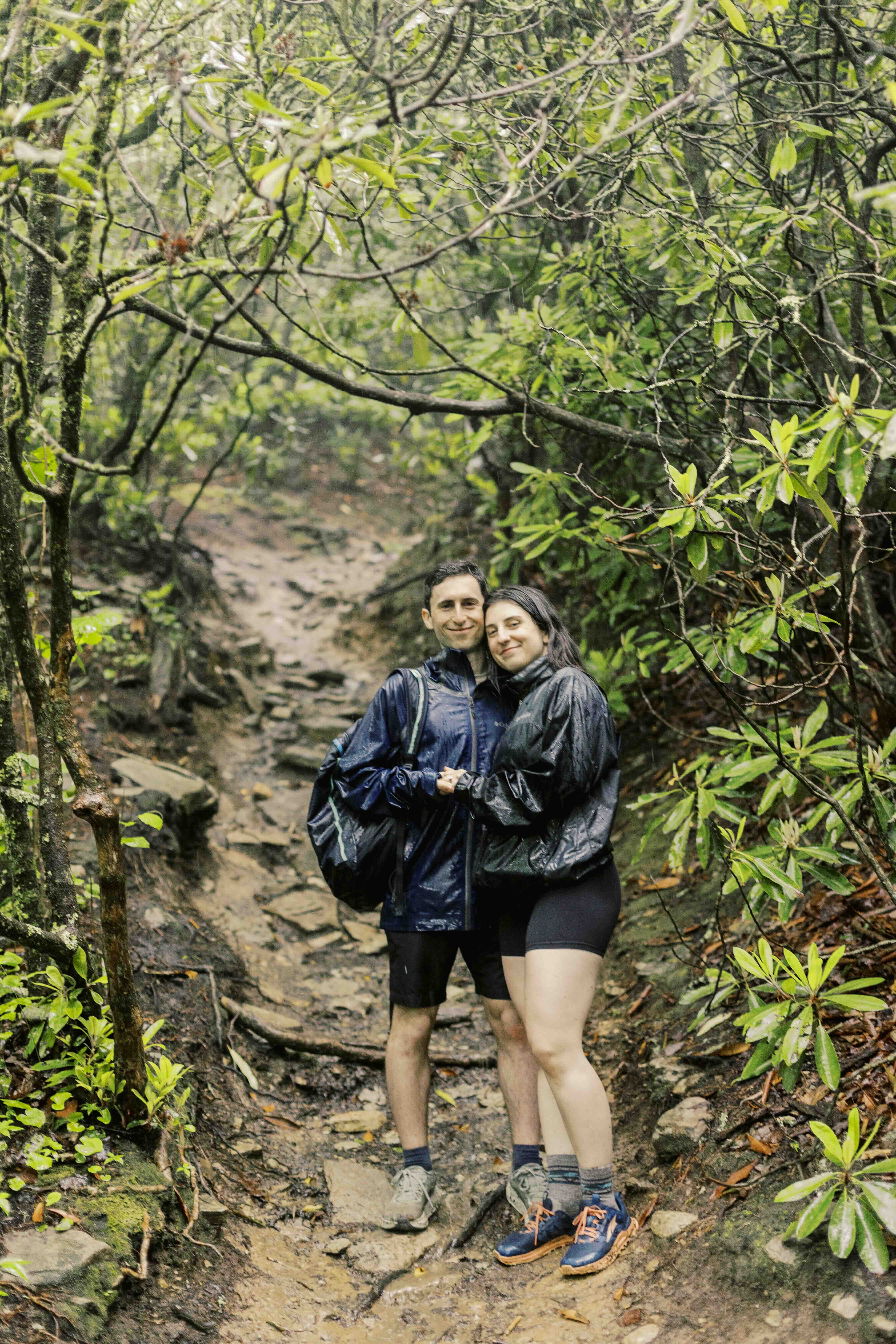 Ari and Montana hugging on a wooded trail