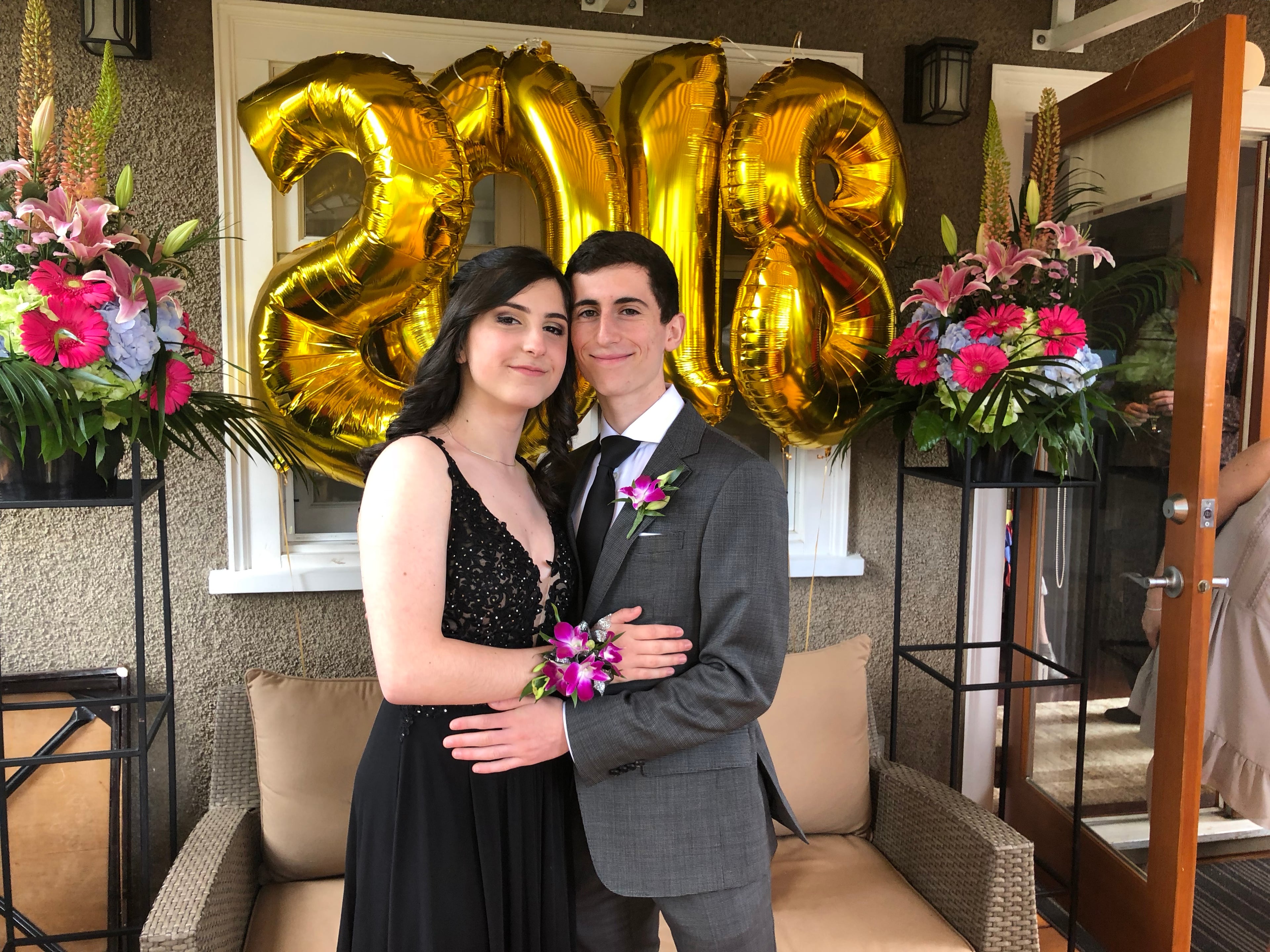 Ari and Montana at prom in front of gold 2018 balloons