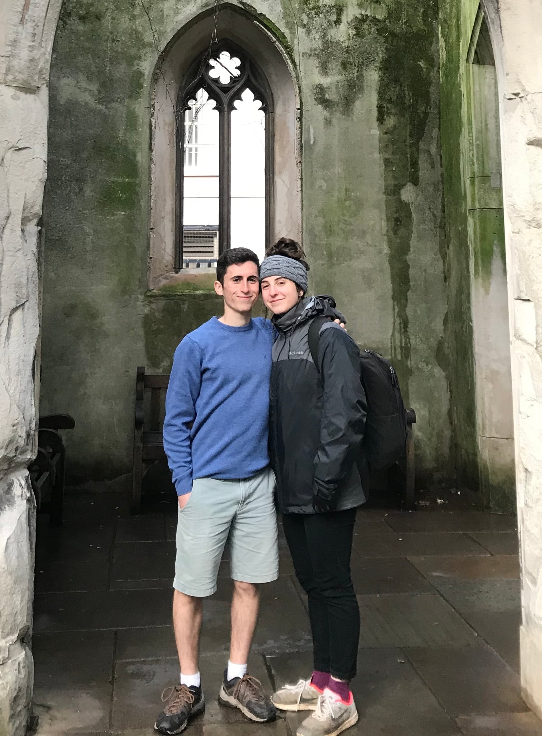 Ari and Montana under an ivy-covered stone arch